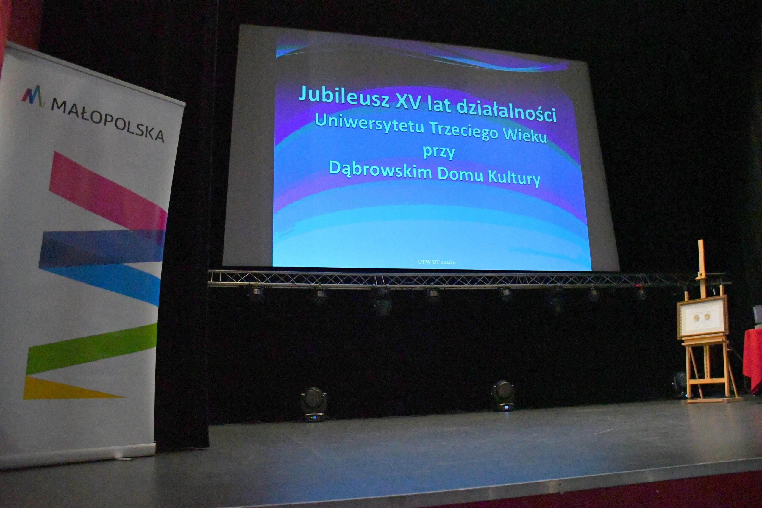 scena w domu kultury ekran z prezentacją i baner małopolski